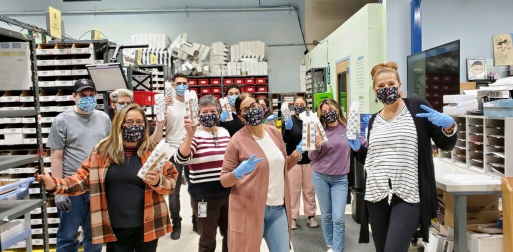 Clear Vision Optical employees on the workflow showing off PPE products they started making during the pandemic