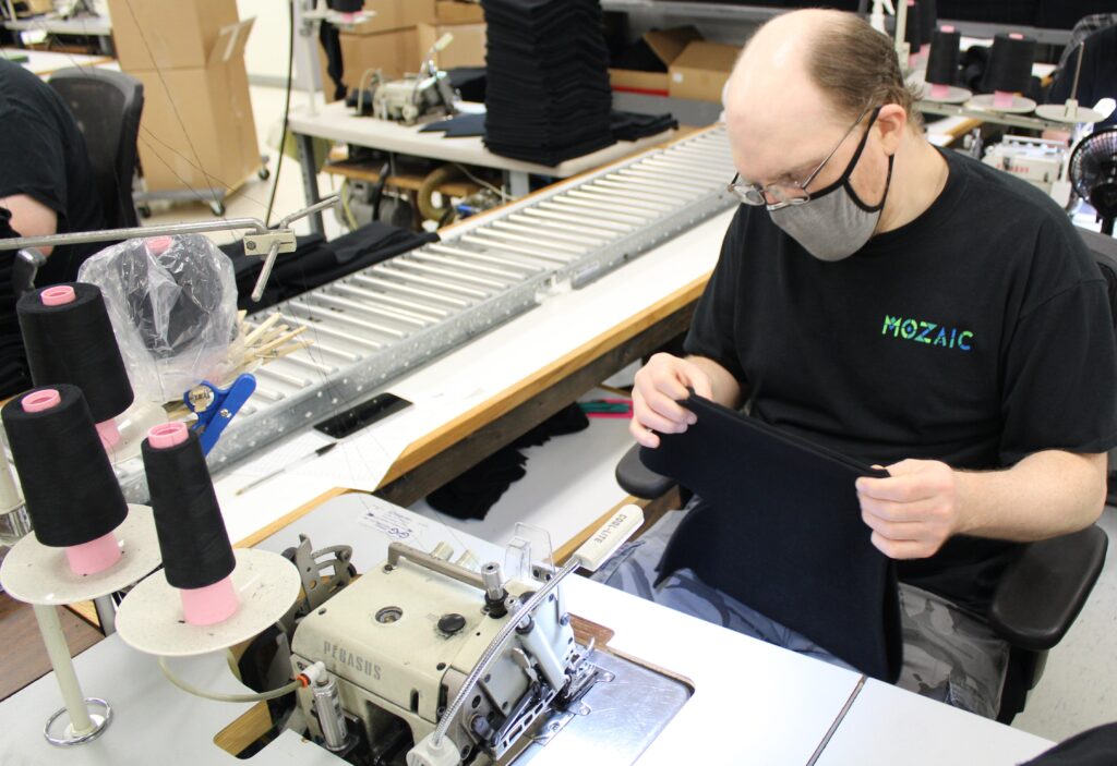 A worker at Mozaic working at a sewing machine