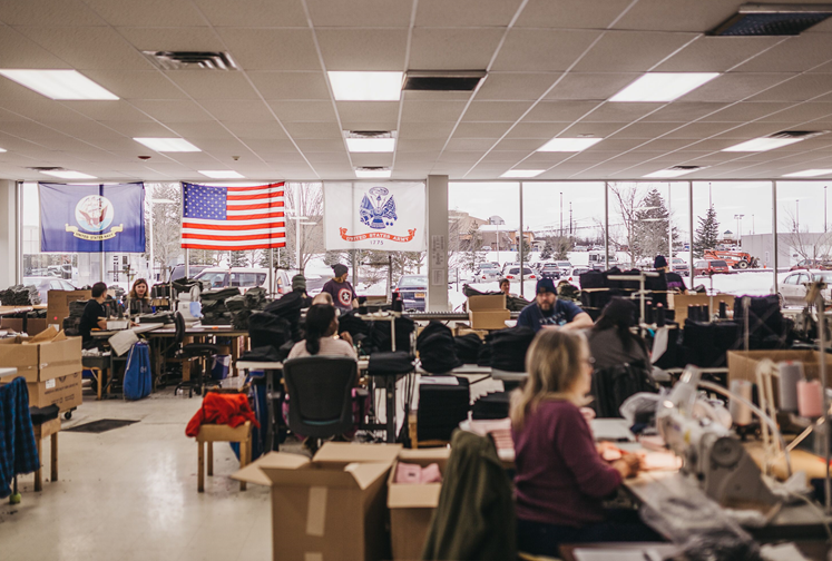 The Finger Lakes textiles office from the inside showing workers with a snowy parking lot scene through the windows.