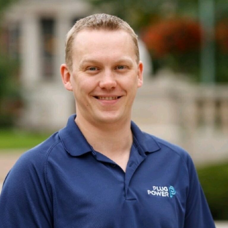Headshot of Christopher Johnson of Plug Power wearing a blue Plug Power polo shirt